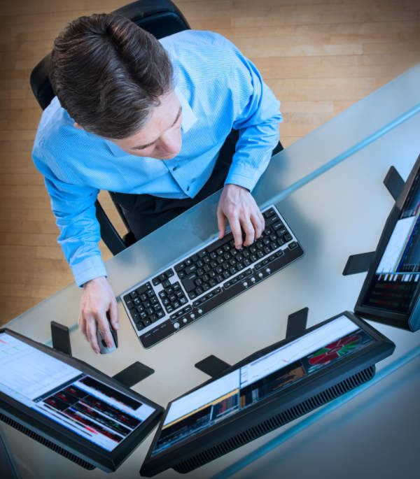 Man trading online with multiple monitors